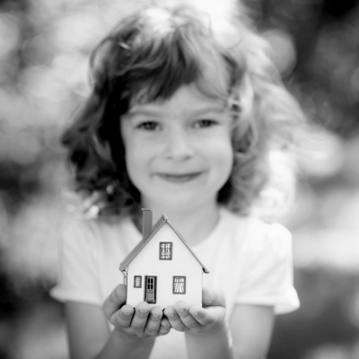 Symbolbild Mädchen mit Hausmodell auf den Händen
